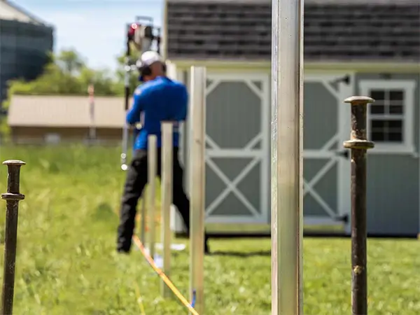 Certified fence contractor installing a 3 rail black aluminum fence with the i Drive method