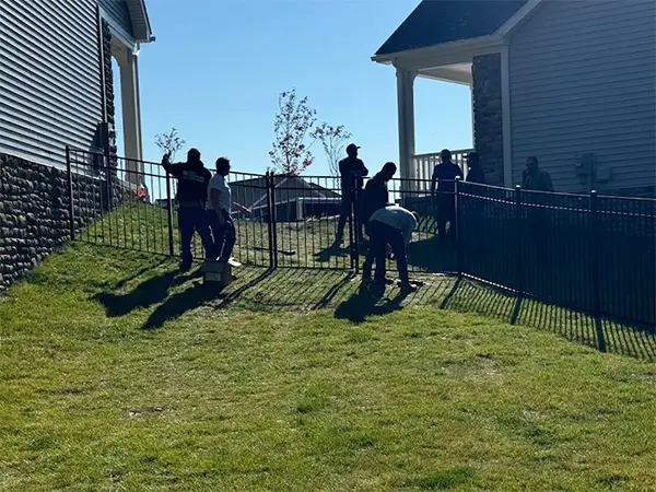 Certified fence contractor installing a 3 rail black aluminum fence with the i Drive method